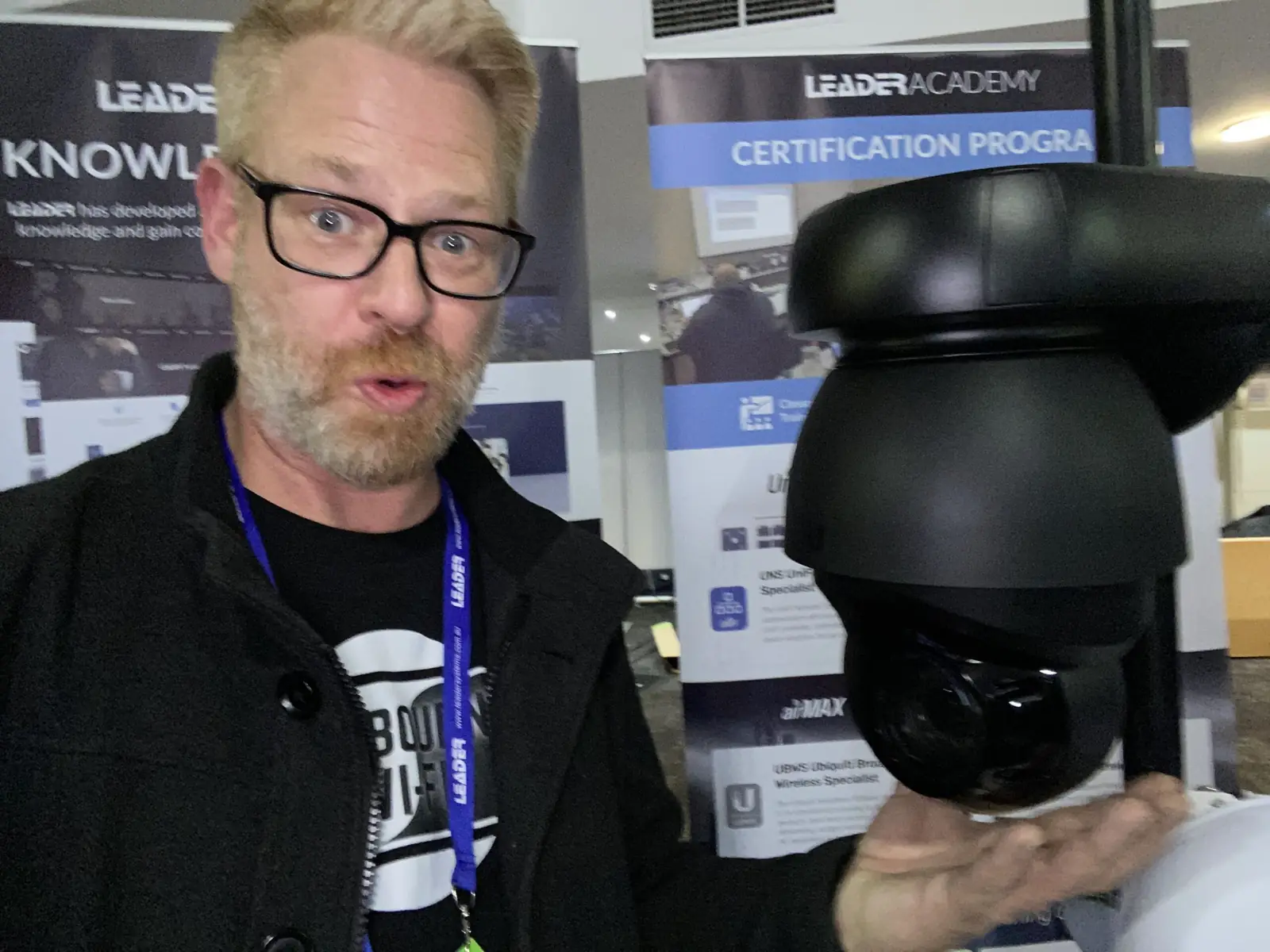 Adam holding a PTZ dome camera at an industry training event