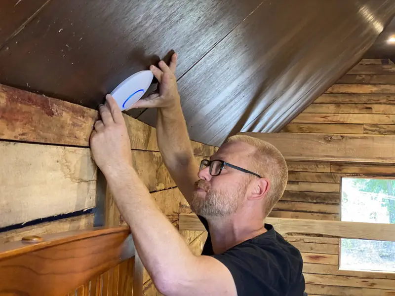 UniFi access point being mounted on a ceiling