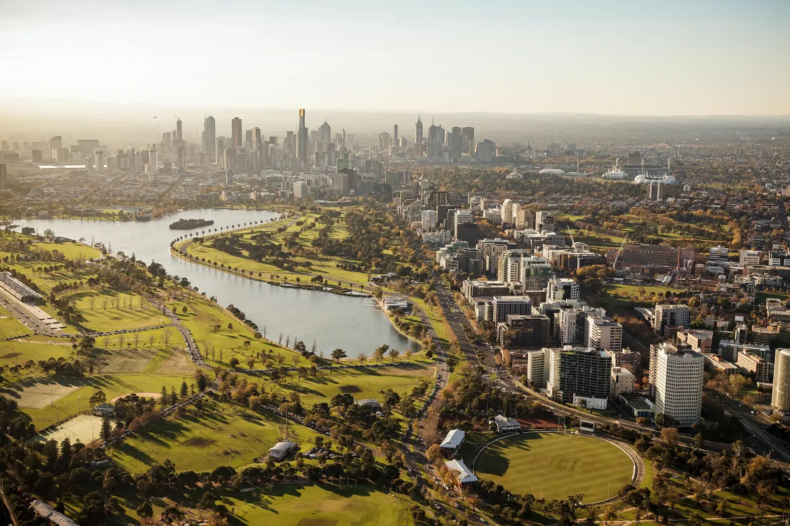 Aerial view over Melbourne, looking across parkland toward the city skyline