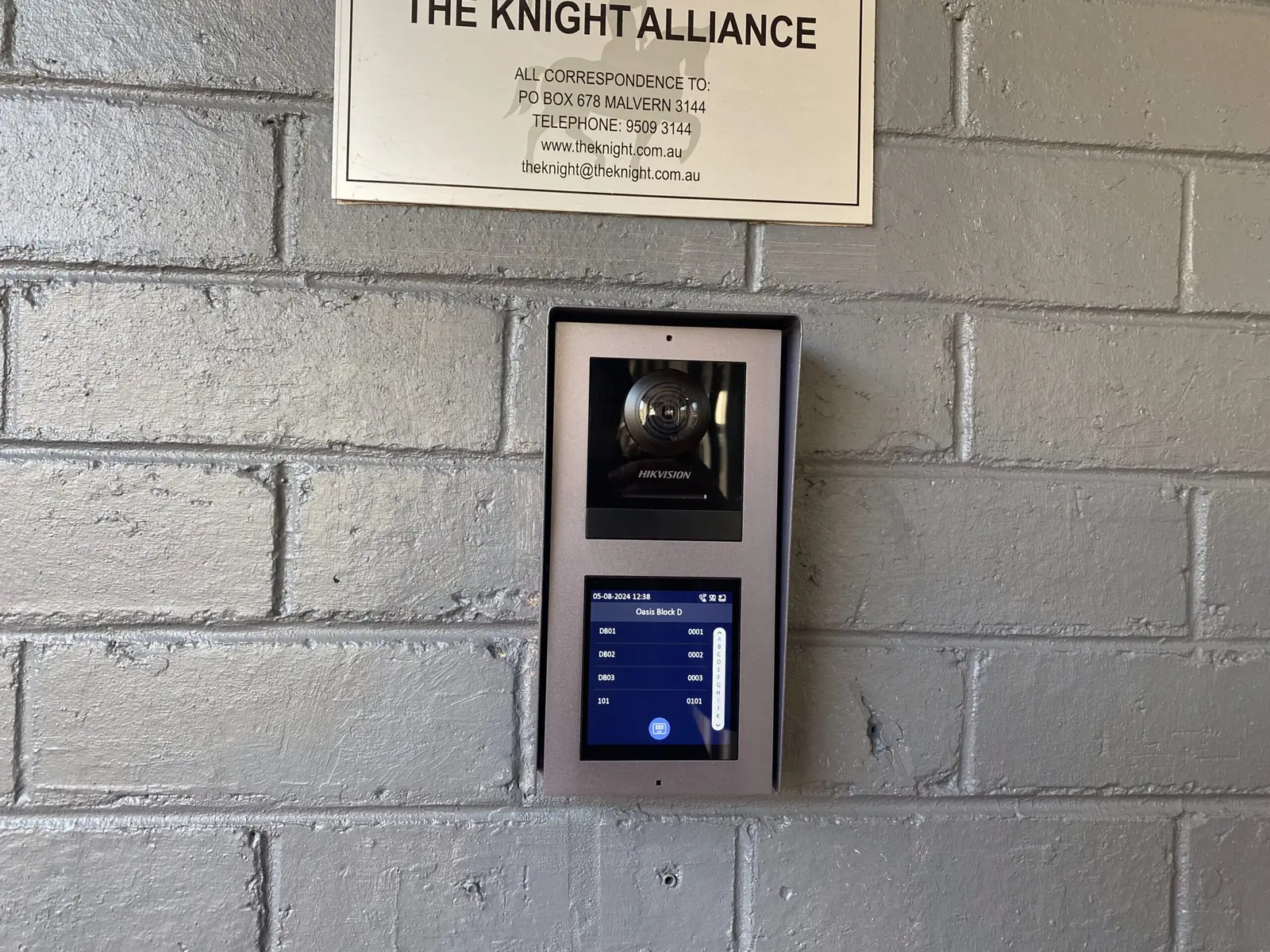 Door access reader with a camera and small display mounted beside a commercial entrance