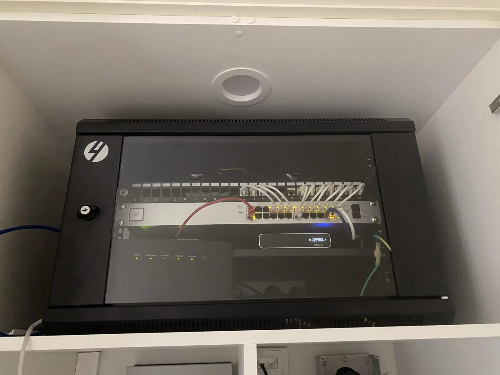 Wall-mounted office comms cabinet with a patch panel, switch and tidy cable management
