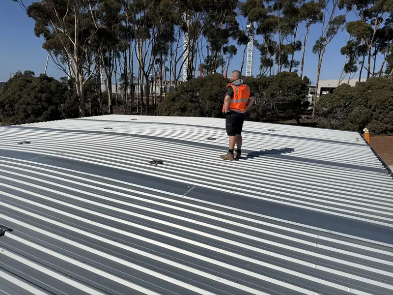 Technician running cable across a Melbourne rooftop