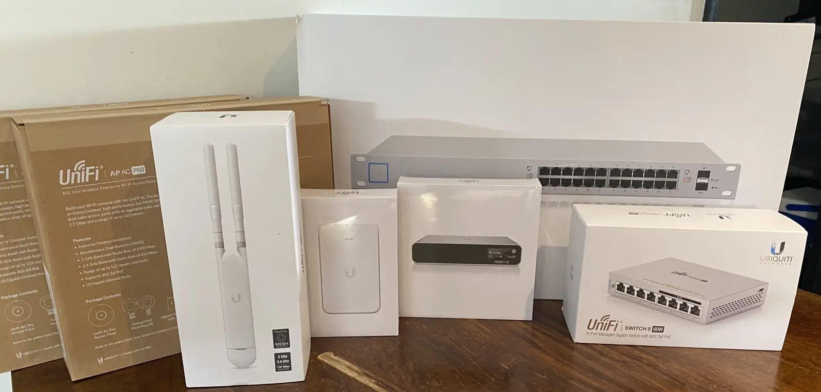 Boxed UniFi access points, switch and rack hardware laid out ready for an install